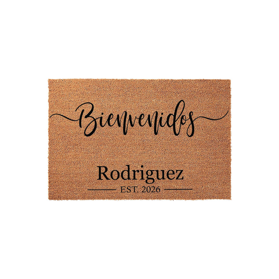 Personalized Bienvenidos coir doormat featuring a natural tan fiber texture with black printed text that includes a family name and established year, creating a welcoming entrance for any home on a clean white studio background.