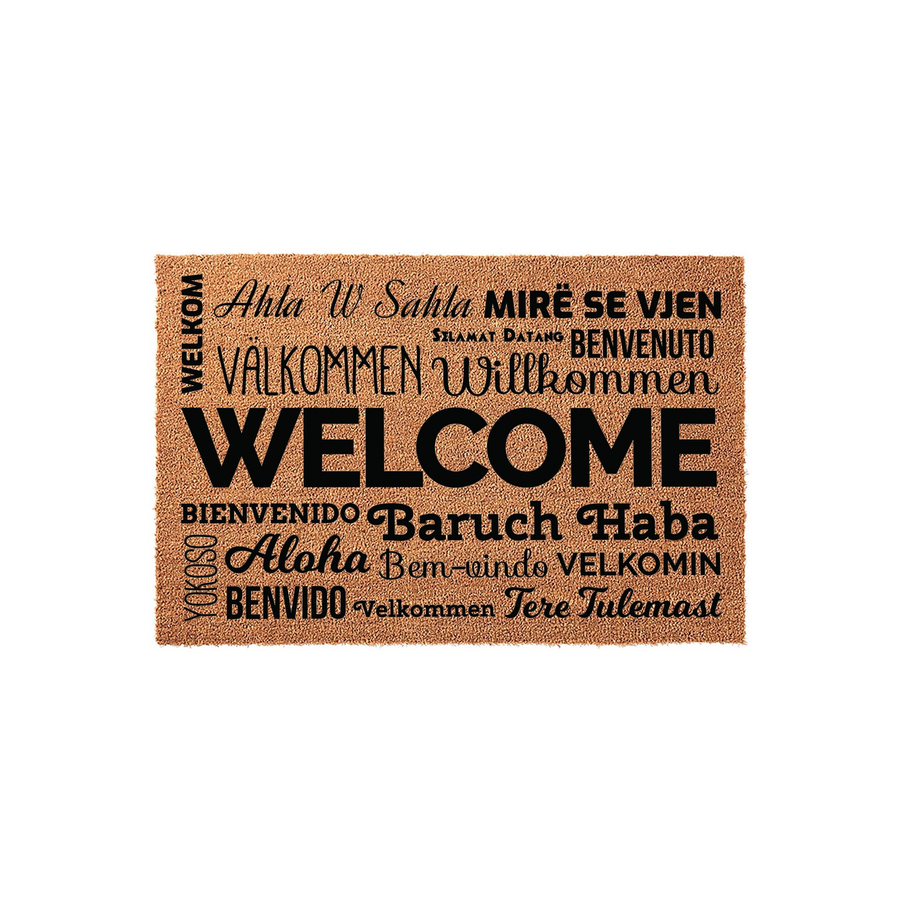 Multilingual Welcome Doormat featuring the word Welcome in large black text surrounded by various international greetings in different fonts, all printed on a natural tan coir fiber mat against a clean white studio background.