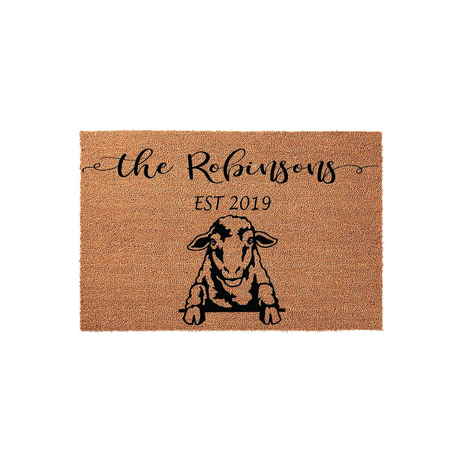 Personalized sheep doormat featuring a rustic coir texture with a black graphic of a sheep peeking over a ledge, customized with a family name and established year printed in elegant black script and serif fonts on a plain white