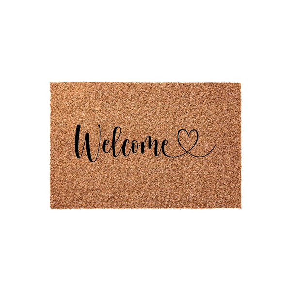 Welcome coir doormat featuring a natural tan fiber texture and elegant black script lettering that reads Welcome with a small heart icon, providing a warm and inviting front porch decor accent for any home entrance or entryway.