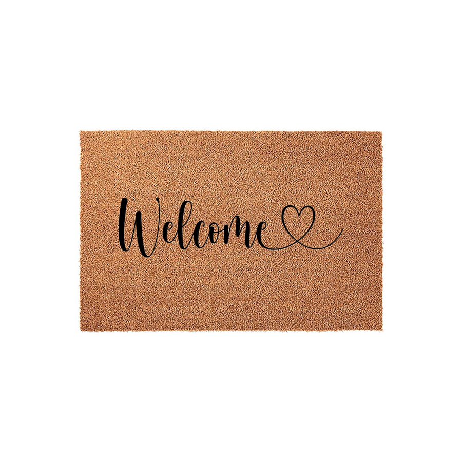 Welcome coir doormat featuring a natural tan fiber texture and elegant black script lettering that reads Welcome with a small heart icon, providing a warm and inviting front porch decor accent for any home entrance or entryway.