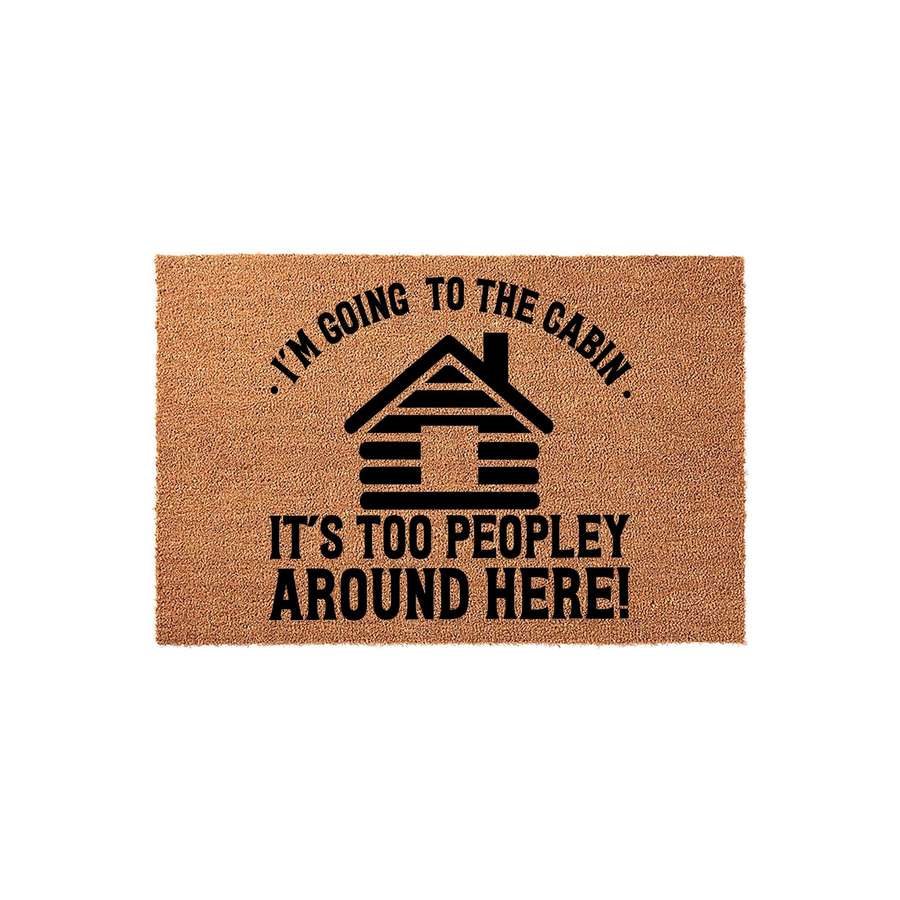 Funny Cabin Doormat featuring a rustic log cabin graphic and the text I am going to the cabin, it is too peopley around here, printed in black ink on a natural tan coir fiber mat against a clean white studio background for home