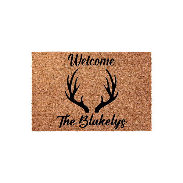 Personalized Antler Welcome Doormat featuring a rustic coir texture with black script text and a central deer antler graphic, providing a charming and custom entryway accent for any home looking for a farmhouse or