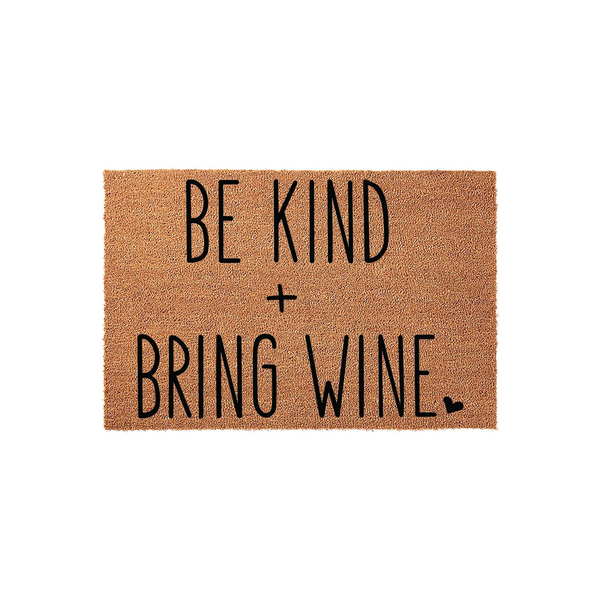 Be Kind and Bring Wine coir doormat featuring bold black lettering on a natural brown fiber background, creating a humorous and welcoming entrance piece for any home front porch or entryway that adds a touch of personality to