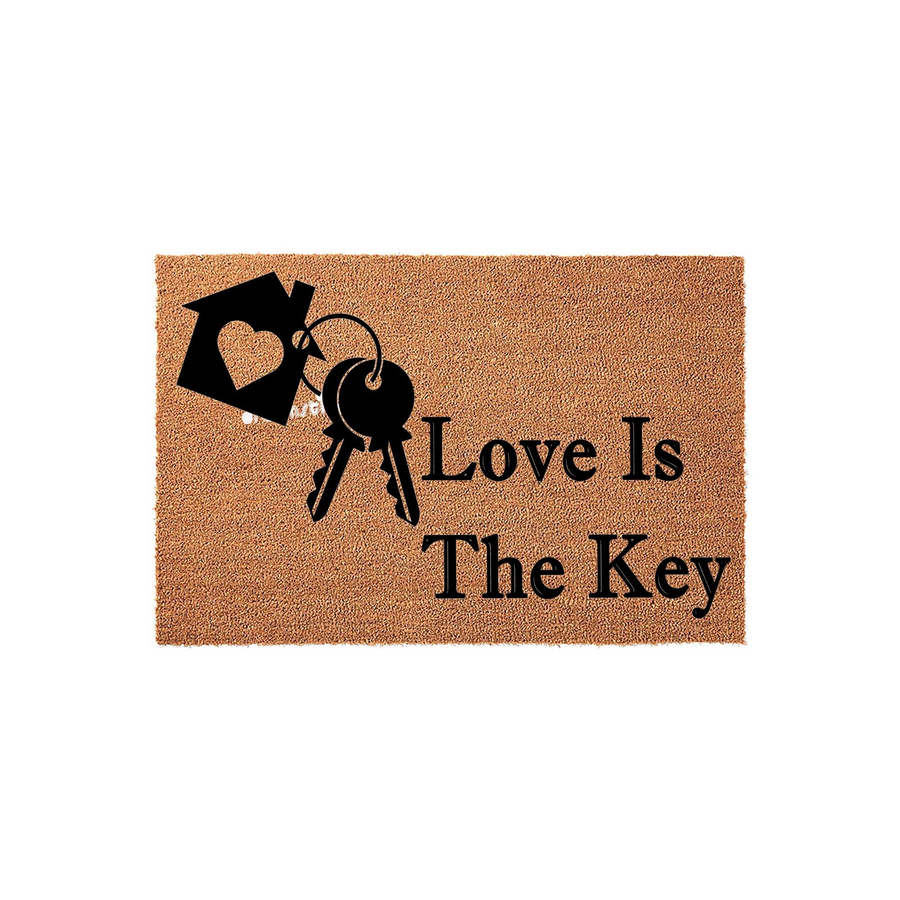Love Is The Key coir doormat featuring a black graphic of a house silhouette with a heart cutout and a set of keys, set against a natural brown fiber background to create a welcoming entrance for any new home or housewarming