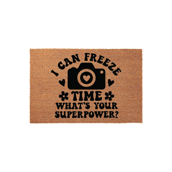 Photography Lover Coir Doormat featuring a black camera icon with a heart lens and the text I Can Freeze Time What Is Your Superpower printed in a bold, retro font on a natural tan fiber background for a unique entryway decor