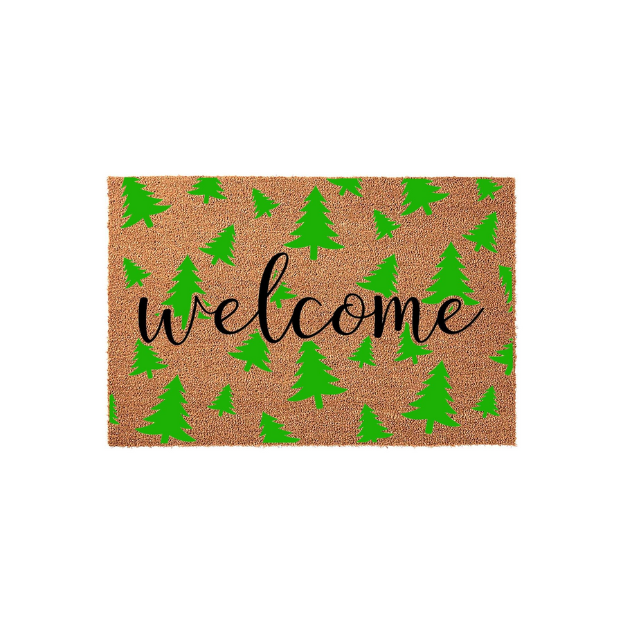 Christmas Tree Welcome Doormat featuring a natural coir fiber texture with a repeating pattern of bright green pine trees and the word welcome written in a stylish black cursive script across the center of this festive holiday