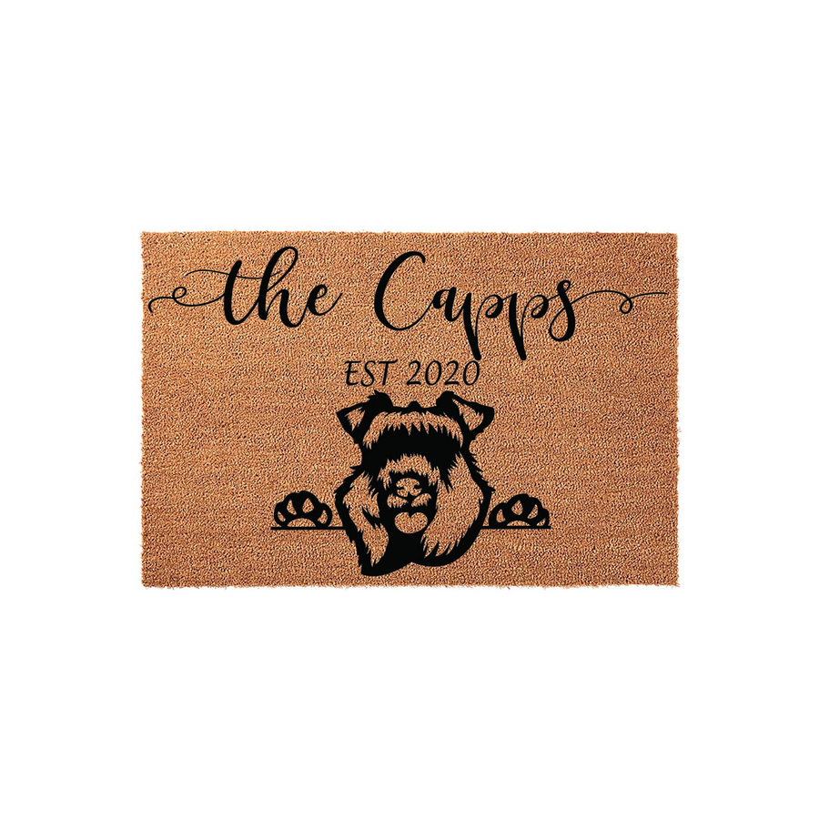 Personalized Schnauzer dog doormat featuring a cute black silhouette of a Schnauzer peeking over the edge with its paws, customized with a family name and established year on a natural tan coir fiber background for a welcoming