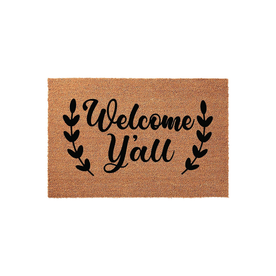 Welcome Y'all coir doormat featuring a natural tan fiber texture and bold black script lettering, framed by elegant leaf sprigs on a clean white background to create a charming farmhouse style entrance for your front porch.