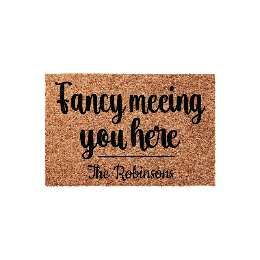 Personalized coir doormat featuring the playful phrase Fancy meeting you here in bold black script, customized with a family name at the bottom, set against a clean white background for a modern and welcoming home entryway decor