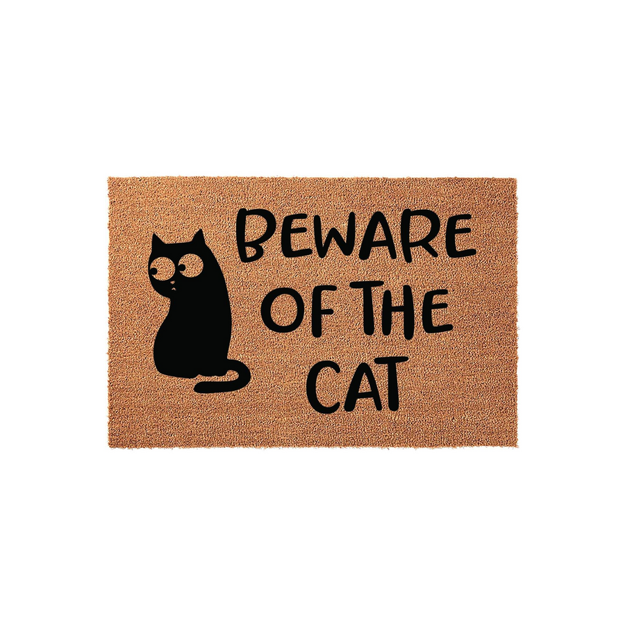 Beware of the Cat coir doormat featuring a whimsical black cat illustration with wide eyes on a natural brown fiber background, providing a humorous and functional welcome mat for any cat lover's front porch or entryway decor.