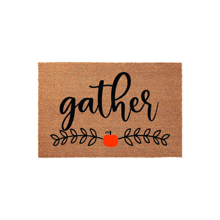 Gather Fall Pumpkin Coir Doormat featuring a natural brown fiber texture with the word gather in black script, accented by a small orange pumpkin and black leafy vine illustrations for a festive autumn entryway decor style.