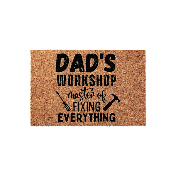 Dad's Workshop Coir Doormat featuring a natural brown fiber texture with bold black text that reads Master of Fixing Everything, accented by small graphic illustrations of a screwdriver and a hammer on a clean white studio