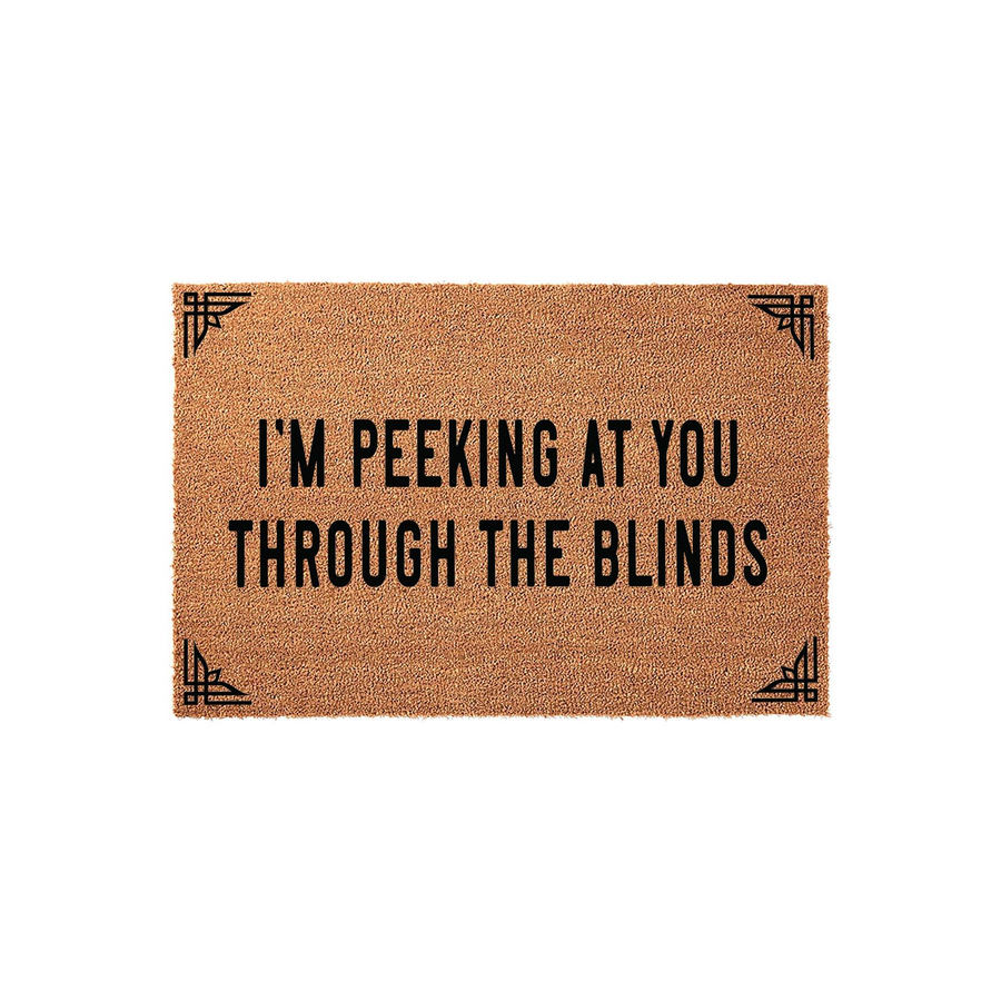 Funny I'm Peeking At You Through The Blinds coir doormat featuring bold black text and decorative corner accents on a natural tan fiber background, creating a humorous and welcoming entrance for your front porch or home entryway.