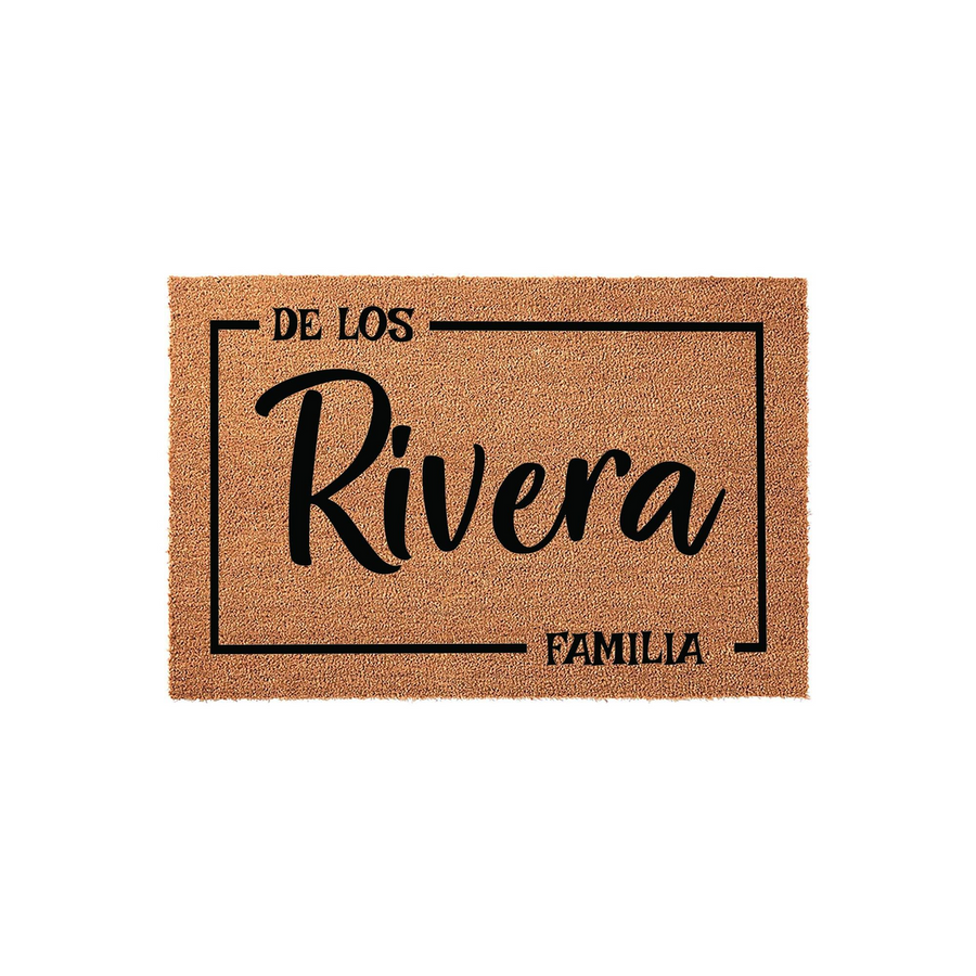 Personalized family name coir doormat featuring a rectangular border design with the text De Los Familia and a custom last name in elegant black script, set against a natural tan fiber background for a welcoming front porch