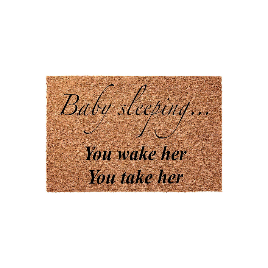 Baby Sleeping Doormat made of natural coir fiber, featuring black printed text that reads Baby sleeping, You wake her, You take her, designed as a humorous front porch sign for new parents to keep visitors quiet at the front door.