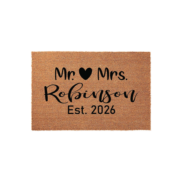 Personalized Mr. and Mrs. coir doormat featuring a black heart icon, a custom family name in elegant script, and an established year, set against a clean white background for a classic wedding or housewarming entryway decor.