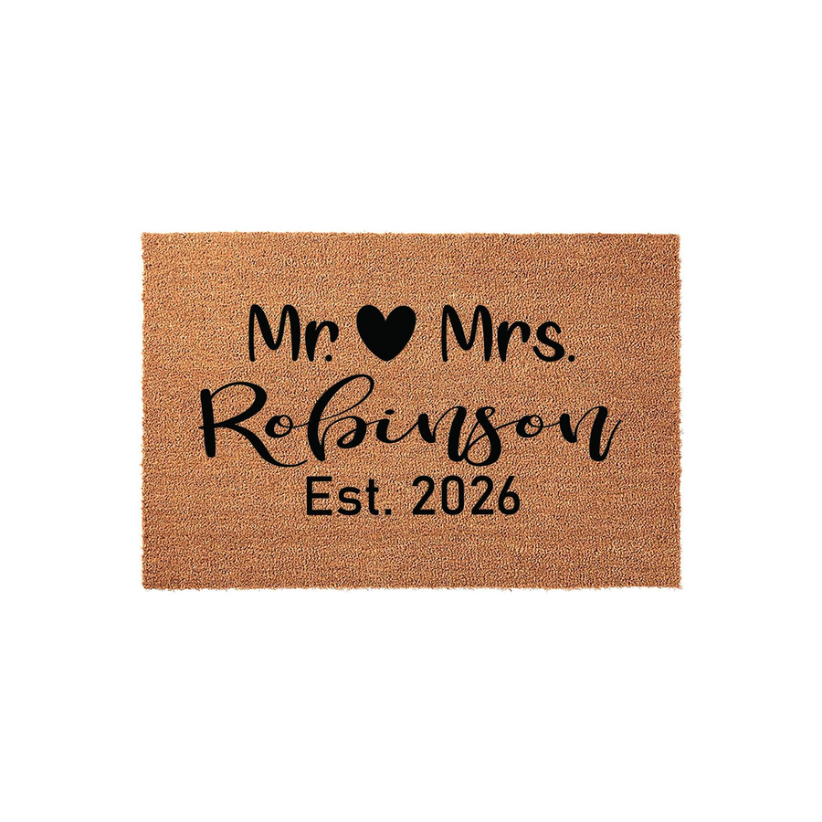 Personalized Mr. and Mrs. coir doormat featuring a black heart icon, a custom family name in elegant script, and an established year, set against a clean white background for a classic wedding or housewarming entryway decor.