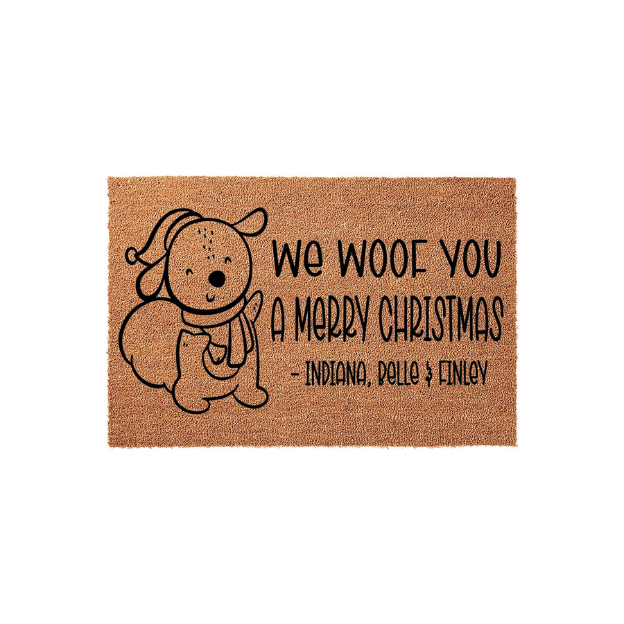 Personalized Dog Christmas Doormat featuring a cute illustrated puppy wearing a winter hat and scarf, with the text We Woof You A Merry Christmas printed on a natural brown coir fiber background for a festive holiday home