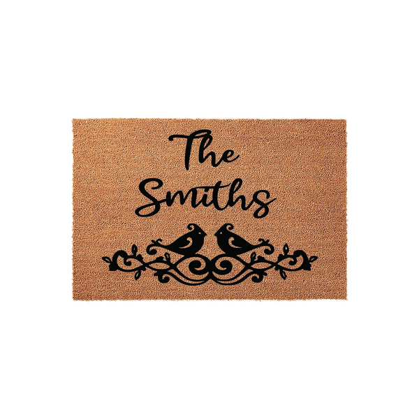 Personalized family name coir doormat featuring a rustic tan texture with black script text and a decorative bird motif, providing a welcoming entrance accent for a home porch or front door entryway with a classic farmhouse