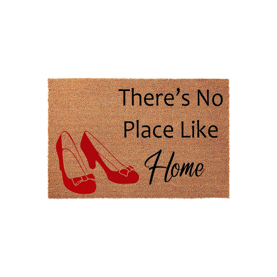 Wizard of Oz themed coir doormat featuring a pair of bright red high heel shoes and the text There is No Place Like Home printed in black, creating a whimsical and welcoming entryway decor piece for any fan of the classic movie.