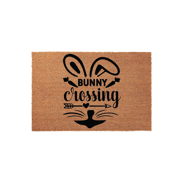 Bunny Crossing Easter Doormat featuring a natural coir texture with a black printed design of rabbit ears, whiskers, and an arrow, creating a festive spring entryway decor piece for your front porch or home entrance during the
