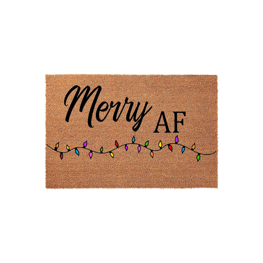 Merry AF Christmas doormat made of natural coir fiber, featuring a funny holiday message in black script and block lettering above a colorful string of festive Christmas lights on a plain white background for a modern home