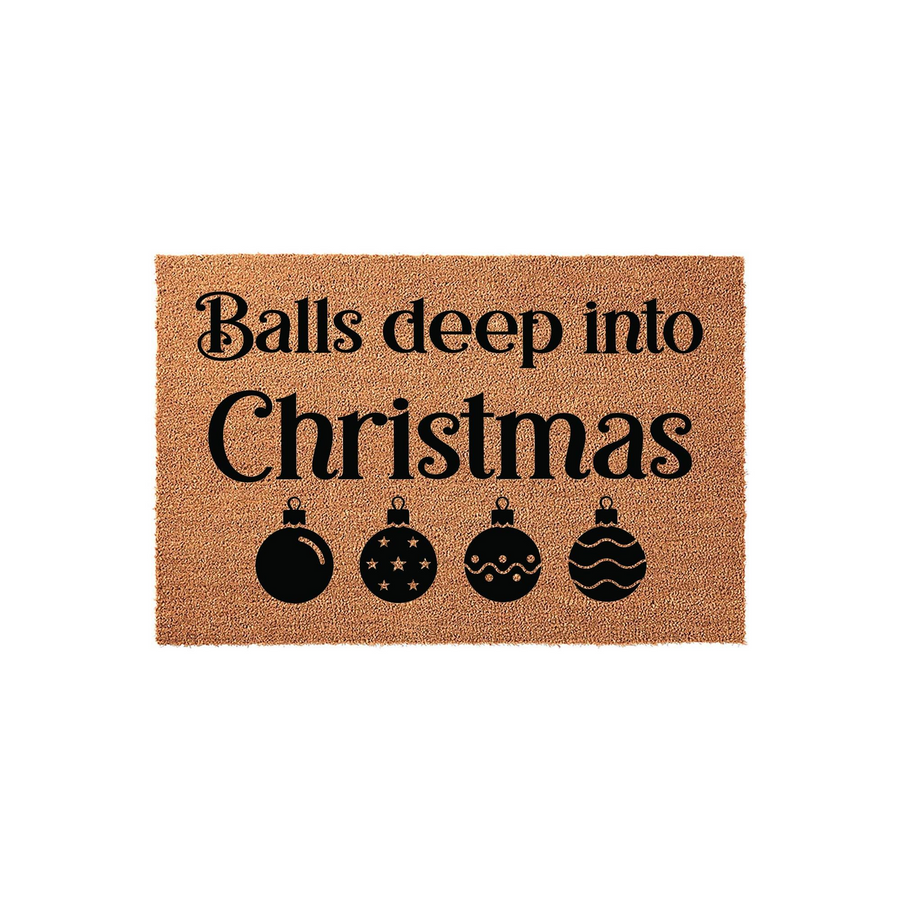 Funny Christmas doormat featuring the text Balls deep into Christmas in bold black lettering, accompanied by four decorative holiday ornament icons on a natural brown coir fiber background for a festive seasonal home entryway