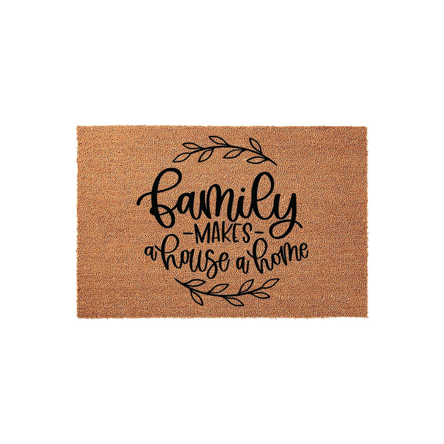 Family Makes a House a Home coir doormat featuring a natural tan fiber texture and black script lettering, accented by delicate leafy branches above and below the text to create a warm and inviting entryway for any family