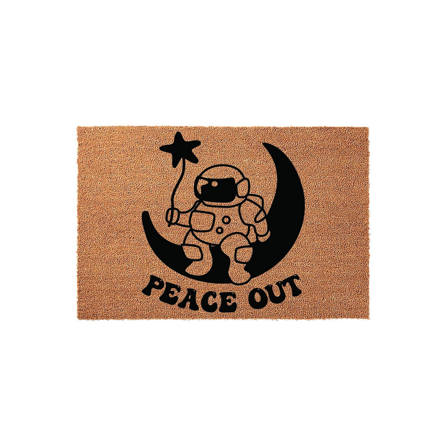 Astronaut Moon Peace Out Coir Doormat featuring a black graphic of an astronaut sitting on a crescent moon while holding a star balloon, printed on a natural brown textured coir fiber mat for a fun space-themed home entryway