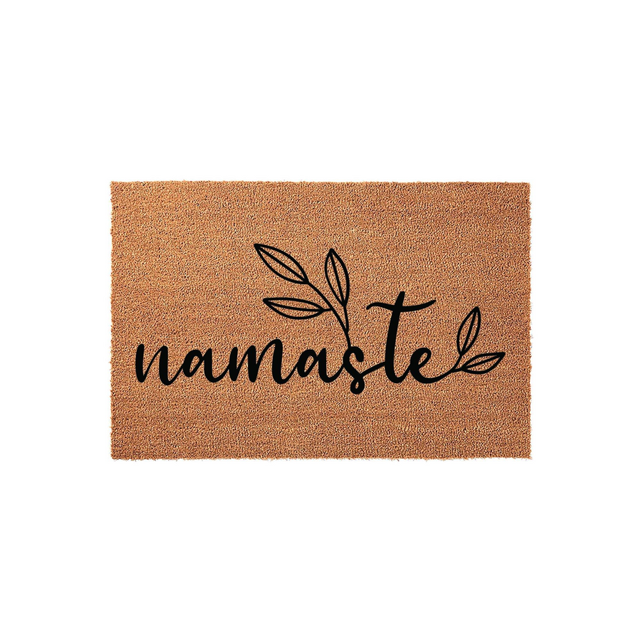 Namaste coir doormat featuring a natural brown fiber texture and black script lettering with a delicate leaf illustration, presented on a clean white background for a modern and welcoming entryway decor aesthetic.