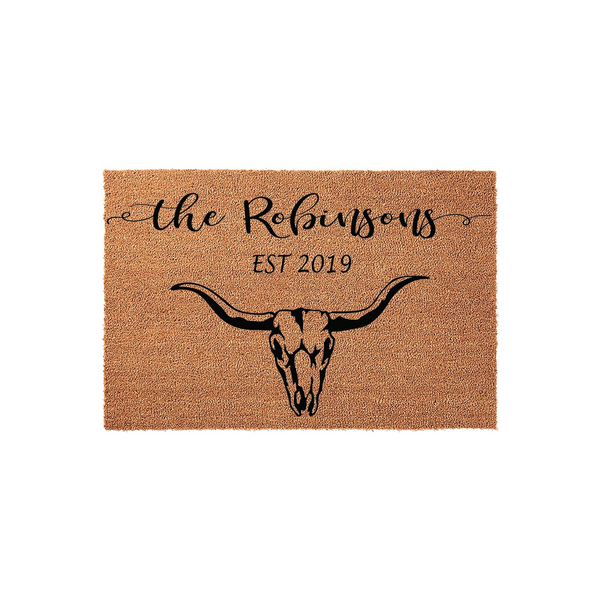 Personalized Western Cow Skull Doormat featuring a rustic coir texture, printed with a black steer skull graphic and customizable family name text, making it a stylish addition to any farmhouse or ranch style front porch entryway.