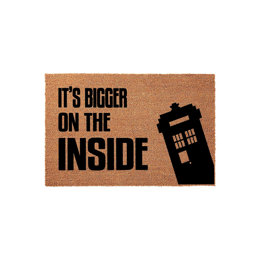 Sci-fi themed doormat featuring a natural coir texture with the black printed text It's Bigger On The Inside and a silhouette of a classic police box, making a fun entrance decor piece for any fan of time-traveling television