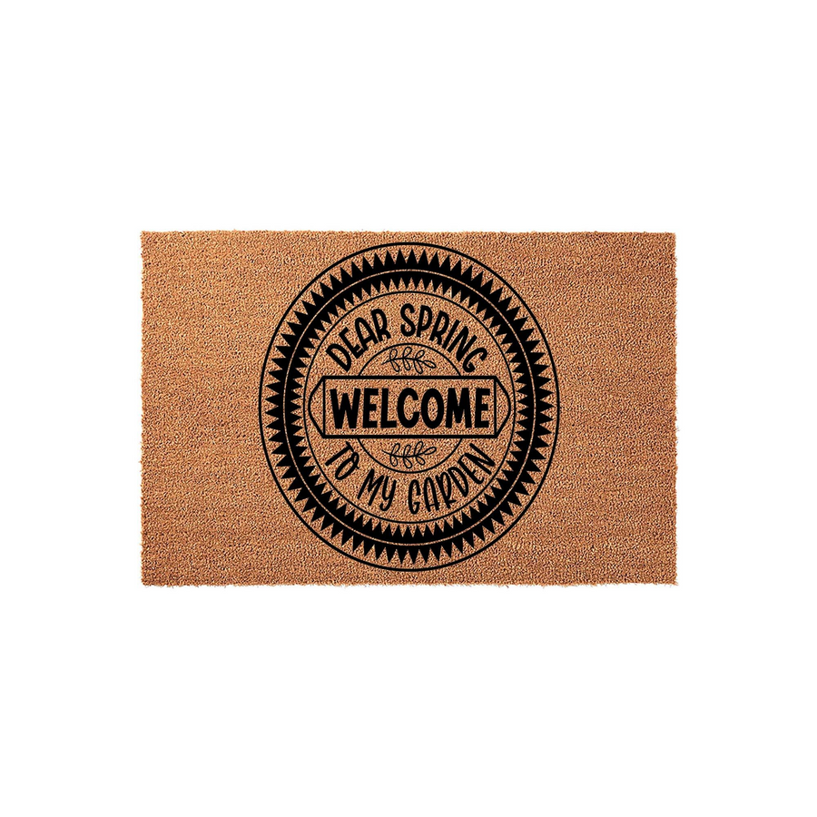 Dear Spring Welcome To My Garden coir doormat featuring a circular black graphic with decorative geometric borders and elegant typography, set against a plain white background for a clean and inviting seasonal porch entryway look.