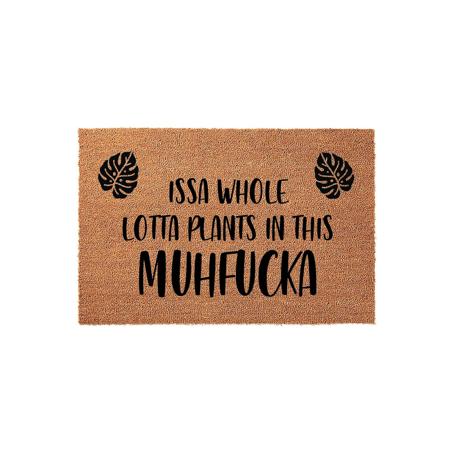 Funny plant lover coir doormat featuring black text that reads Issa Whole Lotta Plants In This Muhfucka, accented by two tropical monstera leaf illustrations on a natural brown fiber background for a humorous home entryway decor.
