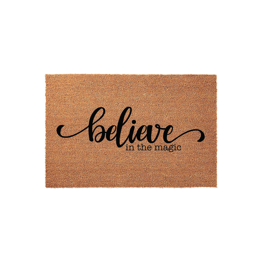 Believe in the Magic coir doormat featuring a natural tan fiber texture and bold black script lettering, providing a festive and welcoming touch to your front porch decor during the holiday season or for everyday home entryways.