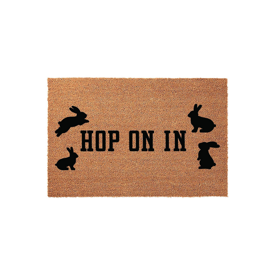 Hop On In Easter Bunny Doormat featuring a natural coir texture with black silhouettes of four rabbits surrounding the playful text, making it a charming spring front porch decor piece for welcoming guests to your home this