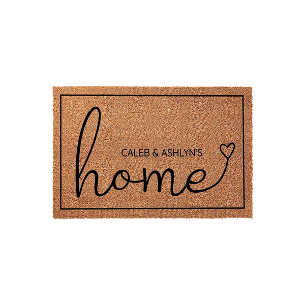 Personalized coir doormat featuring the word home in elegant black script with a heart accent, designed as a custom entryway rug that can be personalized with a family name for a welcoming touch to any front porch or home