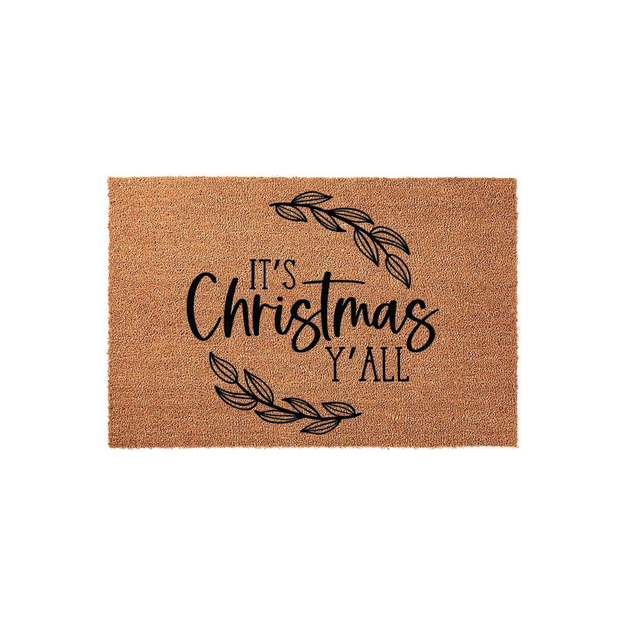 It's Christmas Y'all coir doormat featuring a natural tan fiber texture with black printed text and elegant leafy branch accents, creating a festive holiday welcome for your front porch entrance during the winter season.