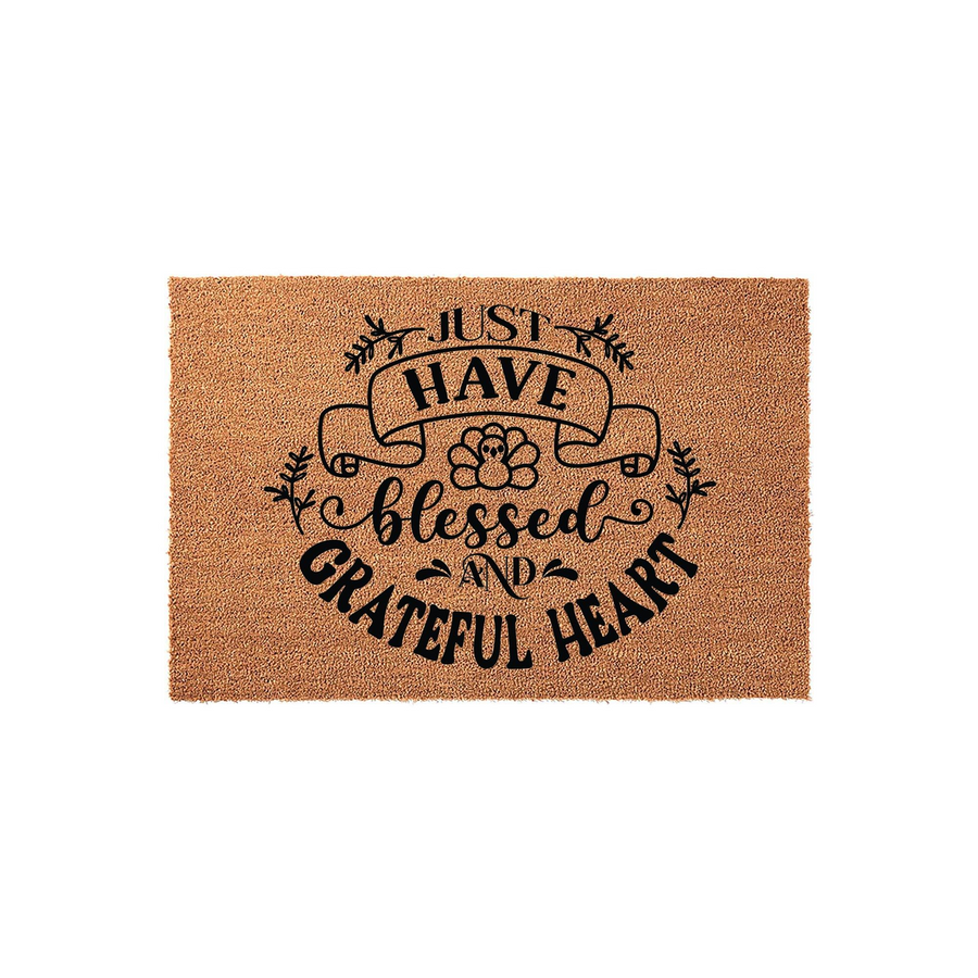 Thanksgiving Turkey Coir Doormat featuring a natural brown fiber texture and black printed text that reads Just Have A Blessed And Grateful Heart, accented with a cute turkey illustration and decorative fall foliage on a plain
