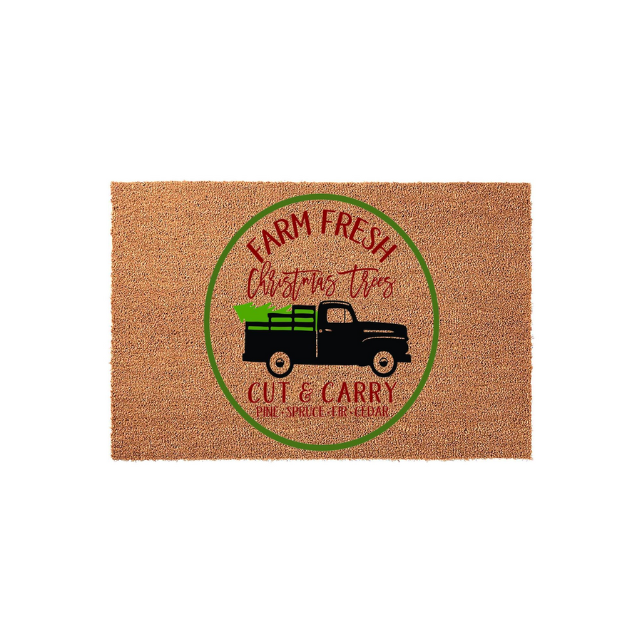 Farm Fresh Christmas Trees doormat featuring a vintage black truck graphic inside a green circle on a natural coir fiber mat, perfect for holiday porch decor with its festive red and green text detailing pine, spruce, fir, and