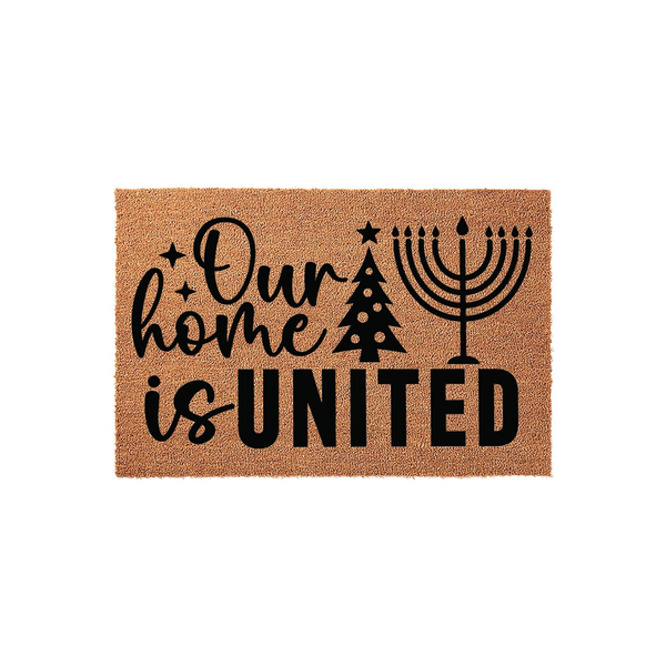 Our Home Is United holiday doormat featuring a natural coir texture with black printed text, a stylized Christmas tree, and a menorah to celebrate both traditions on this festive seasonal welcome mat for your front porch entryway.