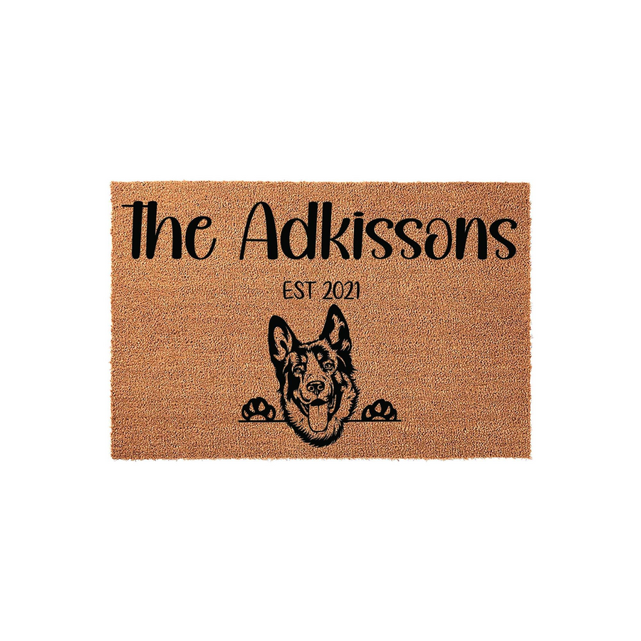 Personalized German Shepherd doormat featuring a natural coir texture with a black printed illustration of a dog peeking over the edge, customized with a family name and established year for a welcoming front porch entrance decor.