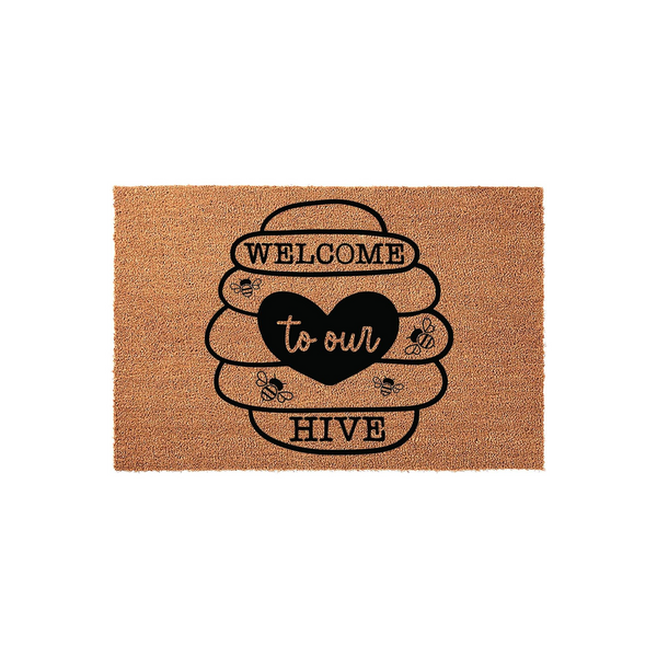 Welcome to Our Hive coir doormat featuring a large black beehive illustration with a central heart, surrounded by small buzzing bees on a natural tan fiber background, creating a charming entryway decor piece for any bee-loving
