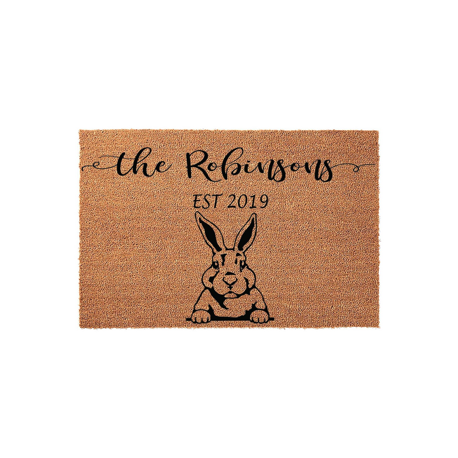 Personalized family name coir doormat featuring a cute black rabbit illustration and custom established date text, set against a plain white background for a clean look that welcomes guests to your home with a charming farmhouse