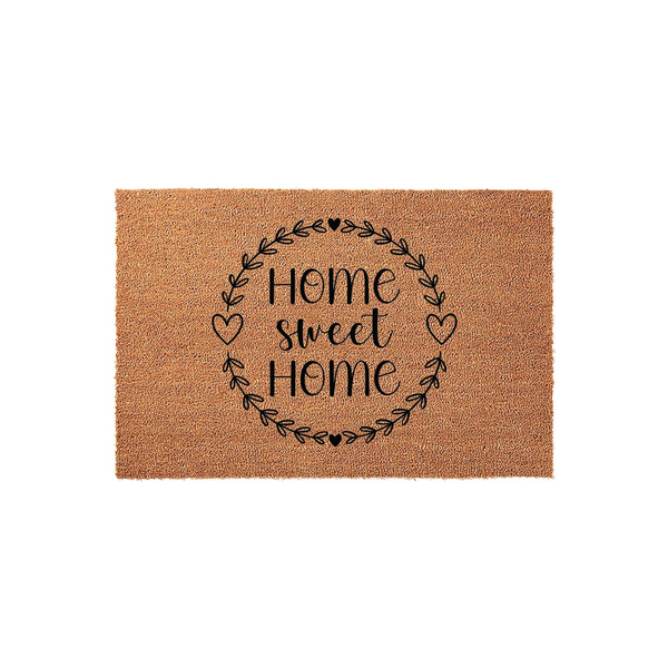 Home Sweet Home coir doormat featuring a black printed wreath design with hearts on a natural brown fiber background, creating a welcoming entryway decor piece for your front porch or house entrance on a plain white studio