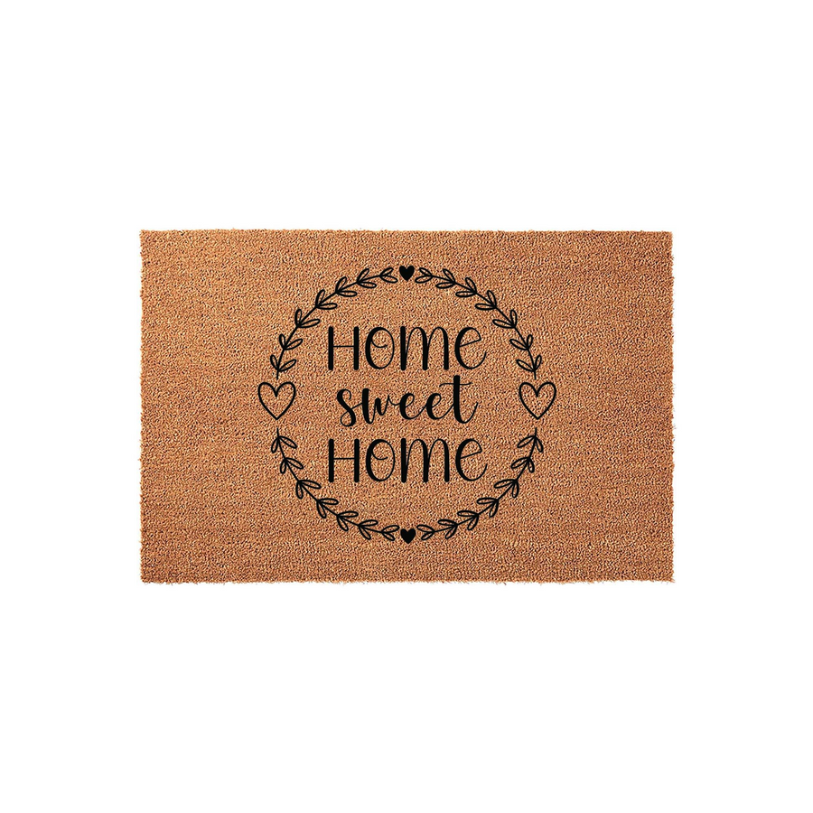 Home Sweet Home coir doormat featuring a black printed wreath design with hearts on a natural brown fiber background, creating a welcoming entryway decor piece for your front porch or house entrance on a plain white studio