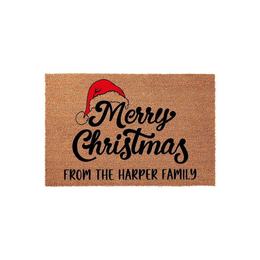 Personalized Merry Christmas coir doormat featuring a festive red Santa hat graphic and custom family name text printed in black script, set against a natural tan fiber background for a welcoming holiday home entrance decor piece.