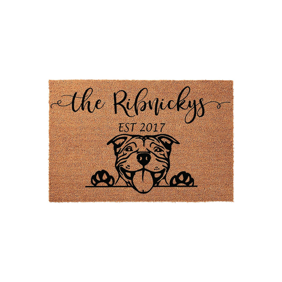 Personalized Pit Bull Dog Doormat featuring a cute illustrated dog peeking over a line with paw prints, customized with a family name and established year on a natural coir fiber background for a welcoming home entrance decor