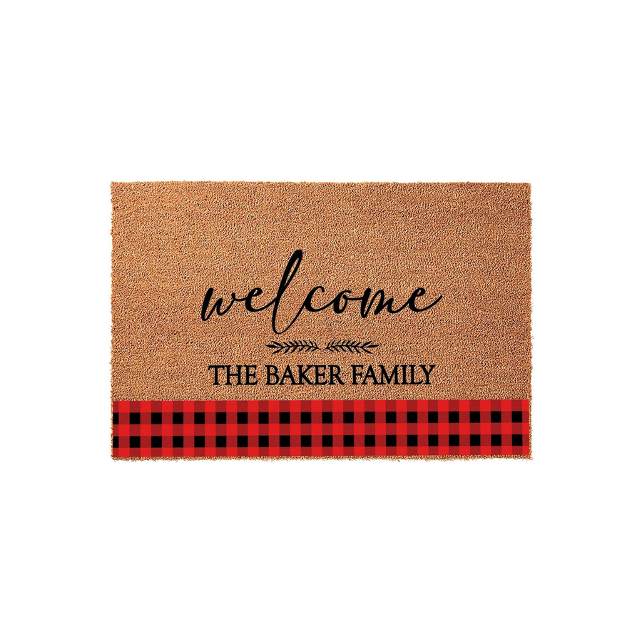 Personalized Buffalo Plaid Welcome Doormat featuring a natural coir texture, black script lettering, and a bold red and black checkered border at the bottom, customized with a family name for a cozy farmhouse entryway decor style.